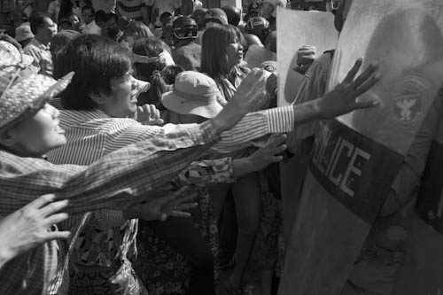 CAMBODIA. Phnom Penh. 29/11/2011: Boeung Kak lake residents trying to force a barrage of policemen blocking their way to a demonstration in front of the municipal office.