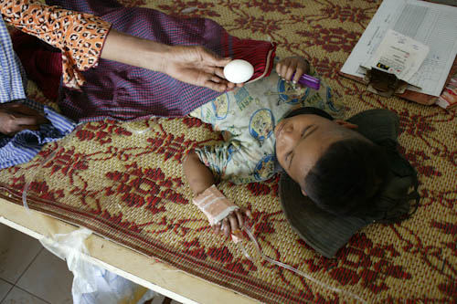 CAMBODIA. Anlong Veang (Oddar Meanchey). 25/12/2003: Child receiving an egg at the paediatric ward at health centre rehabilitated by MSF.