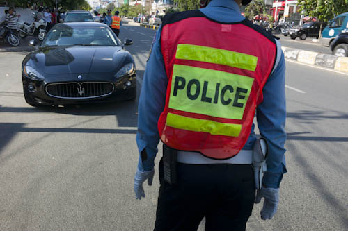 CAMBODIA. Phnom Penh. 19/04/2012: A Maserati being controlled by the police on Monivong Blvd. The driver, probably a mechanic, was wearing tongs.