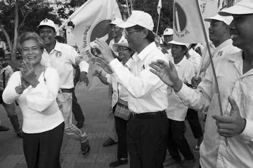 CAMBODIA. Phnom Penh. 18/05/2012: Tioulong Saumura, Sam Rainsy Party MP, dancing with militants at first election campaign parade through the streets of Phnom Penh.