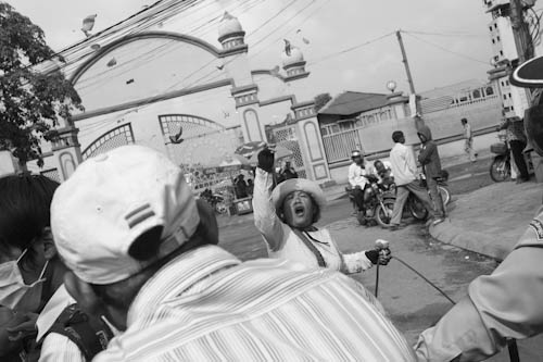 CAMBODIA. Phnom Penh. 2/10/2012: Boeung Kak Lake community representative throwing lotus flower petals on police when  being prevented by a police road block to go to the Municipality to ask about progress regarding the outlining of the 12,44Ha for an on site development promised by Prime Minister Hun Sen.