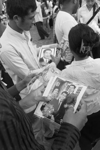 CAMBODIA. Phnom Penh. 19/10/2012: Peddlers selling photographs of the monarch to people paying tribute to King Norodom Sihanouk in front of the Royal Palace.