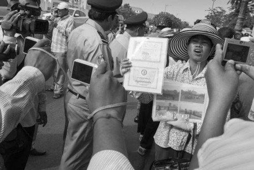 CAMBODIA. Phnom Penh. 23/01/2013: Boeung Kak Lake community member explaining their situation to the police and the press in front of the Council of Ministers, while expecting news about the petition they handed over several days ago.