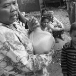 CAMBODIA. Phnom Penh. 5/01/2013: Woman holding her bag of 5Kg of rice at the Borei Keila community distribution of rice left over from the eviction anniversary celebration held a few days earlier.