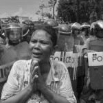 CAMBODIA, Phnom Penh. 29/05/2013: Boeung Kak Lake member, crying in front of the riot police, when demonstrating for a solution on their land issue in front of the Municipality Building, blocking Monivong Boulevard, ended up by being dispersed by water cannons.
