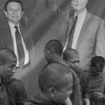 CAMBODIA. Phnom Penh. 26/08/2013: Monks in front of a poster depicting Kem Sokha and Sam Rainsy, Co-Presidents of the CNRP while the opposition CNRP gathered over 6,000 supporters on Freedom Place to keep pressure on the ruling CPP to review the 2013 parliamentary elections results which saw the CPP lose a considerable amount of seats to the CNRP.