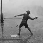 CAMBODIA. Phnom Penh. 15/09/2013: CNRP supporter throwing rocks at the police near a torn down barbed wire barricade on first day of a planned 3-day protest by the opposition CNRP to fight the results of the 2013 legislative elections which, according to the CNRP, were wrought with fraud and saw the ruling CPP lose a considerable number of seats to the CNRP while officially still maintaining a small majority.