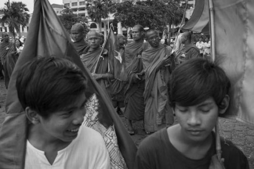 CAMBODIA. Phnom Penh. 21/09/2013: Monks getting ready befor before participating at the 3d demonstration of the day. Staged by the Boeung Kak Lake community, monks and sympathizers marched from Wat Phnom to the barricades set up by the police near the Royal Palace to pray, chant for peace and justice after the 2013 legislative elections.