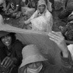 CAMBODIA. Phnom Penh. 6/10/2013: Opposition CNRP supporters shelter from the rain when attending a 'public forum' at 'Freedom Place', two weeks after the CNRP boycotted the opening ceremony of the 2013 legislature.