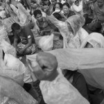 CAMBODIA. Phnom Penh. 6/10/2013: Opposition CNRP supporters shelter from the rain when attending a 'public forum' at 'Freedom Place', two weeks after the CNRP boycotted the opening ceremony of the 2013 legislature.