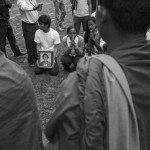 CAMBODIA. Phnom Penh. 18/10/2013: Photograph of Mao Sok Chan who was fatally shot during the aftermath of September 15th opposition CNRP demonstration, carried by a member of a youth movement during a prayer in his memory at Wat Phnom. The ceremony will be interrupted by municipality security guards.