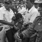 CAMBODIA. Phnom Penh. 13/10/2013: Undercover agent carrying a fake press card and a gun taken away by policemen after he was mobbed by an angry crowd at an unauthorized protest by the teacher's union for better wages and to end corruption.