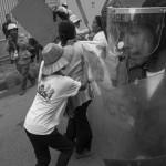 CAMBODIA. Phnom Penh. 17/10/2013: Member of the Borei Keila community pushing past a police line when demonstrating for a solution to their eviction in January 2012.