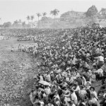 CAMBODIA. Phnom Penh. 20/11/1991: A crowd watches the first Water Festival boat races on the Tonle Sap River to be held after the fall of the Khmer Rouge regime.