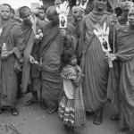 CAMBODIA. Phnom Penh. 22/11/2013: Street child begging money from monks supporting Yorm Bopha, land rights activist, appearing at the Supreme Court for her last appeal.