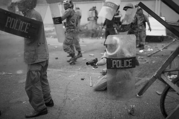 CAMBODIA. Phnom Penh. 24/01/2009: Police aiming tear gas at mans height to inhabitants of Dey Krohom before final eviction.