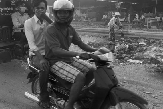 CAMBODIA. Phnom Penh.4/01/2014: Scavenger collecing metal from burned tyres after the violent crackdown on garment workers strike of the day before at Veng Sreng road in the industrial area of Phnom Penhr.