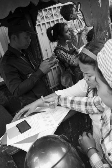 CAMBODIA. Phnom Penh. 13/01/2014: Members of the Boeung Kak lake community thumbprinting a document when some 80 workers' unions representatives, monks and activists gathered in front of the UNHCHR to deliver a petition requesting the liberation of 23 workers, activists and union leaders who were arrested during the violent crackdowns on striking workers of January 2nd and 3rd.