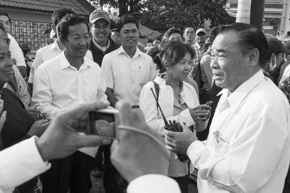 CAMBODIA. Phnom Penh. 14/01/2014: Rong Chhun, Leader of the Independent Teachers Association, greeted by Ho Vann, CNRP MP, before entering the Municipal Court of Phnom Penh where he, Sam Rainsy and Kem Sokha, opposition CNRP co-Presidents, are summonsed to answer questions about their alleged incitement to violence during the weeks-long workers srike.