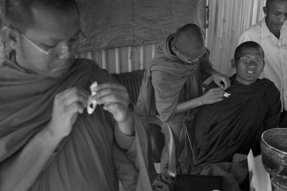 CAMBODIA. Phnom Penh. 15/01/2014: Monks don funeral ribbons before a buddhist ceremony organised by the Boeung Kak lake community to commemorate the 4 garment workers who were killed on January 3rd, during a violent crackdown by the army on a workers' strike.