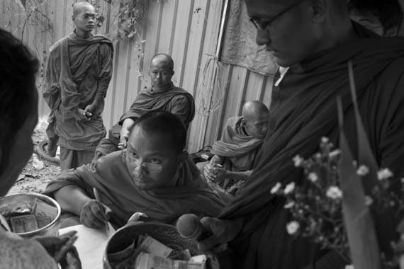 CAMBODIA. Phnom Penh. 15/01/2014: Monks collecting donations before a buddhist ceremony organised by the Boeung Kak lake community to commemorate the 4 garment workers who were killed on January 3rd, during a violent crackdown by the army on a workers' strike.