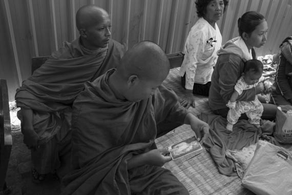 CAMBODIA. Phnom Penh. 15/01/2014: Wife and child of a killed worker attending a buddhist ceremony organised by the Boeung Kak lake community to commemorate the 4 garment workers who were killed on January 3rd, during a violent crackdown by the army on a workers' strike.