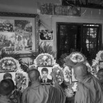 CAMBODIA. Phnom Penh. 15/01/2014: Monks preparing the photographs of killed workers before a buddhist ceremony organised by the Boeung Kak lake community to commemorate the 4 garment workers who were killed on January 3rd, during a violent crackdown by the army on a workers' strike.