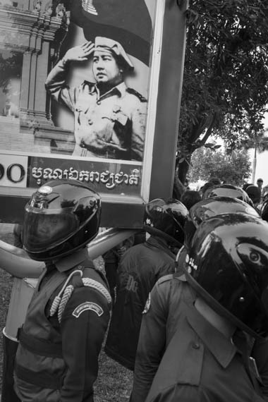 CAMBODIA. Phnom Penh. 19/01/2014: Municipality thugs under a poster representing King Father Sihanouk when preventing activists from IDEA and other human rights organisations to hold a demonstration requesting the release of 23 people arrested on January 2nd and 3d during a violent crackdown on striking workers.