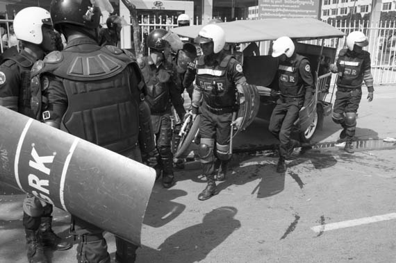 CAMBODIA. Phnom Penh. 27/01/2014: Members of the riot police and the gendarmerie confiscate evidence left by supporters of Mam Sonando, director of Beehive Radio, after a protest in front of the Ministry of Information to request a TV frequency.