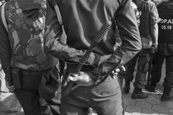 CAMBODIA. Phnom Penh. 29/01/2014: Municipal Guard holding a truncheon when stopping a group of citizens representing nearly 200 NGO's and organisations, touring several embassies to deliver a petition requesting the liberation of 23 people arrested and jailed during the January 2nd and 3d violent crackdown on a garment worker's strike.