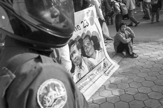 CAMBODIA. Phnom Penh. 29/01/2014: A group of citizens representing nearly 200 NGO's and organisations, is stopped by riot police and municipality guards and forced to proceed by tuk tuk when touring several embassies to deliver a petition requesting the liberation of 23 people arrested and jailed during the January 2nd and 3d violent crackdown on a garment worker's strike.