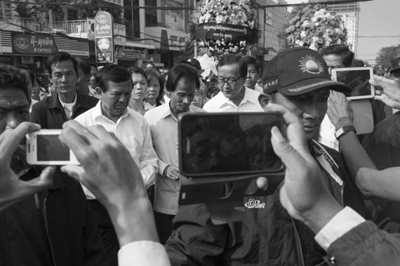 CAMBODIA. Phnom Penh. 22/01/2014: For the 10th commemoration of the assassination of union leader Chea Vichea, a small crowd, led by Chea Mony, Union Leader and Chea Vichea's brother, Sam Rainsy and Kem Sokha, opposition CNRP Co-Presidents, marched from the FUTWC office to the statue of Chea Vichea.