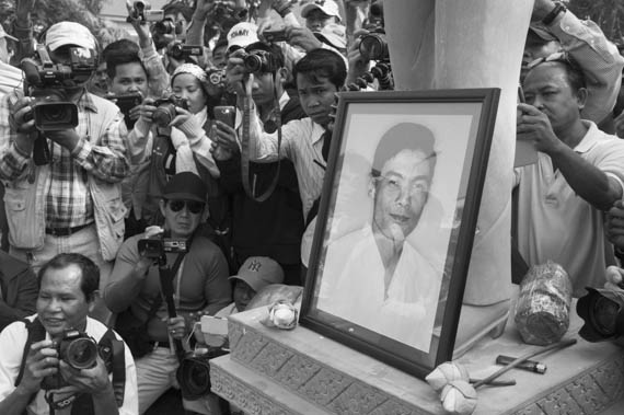 CAMBODIA. Phnom Penh. 22/01/2014: For the 10th commemoration of the assassination of union leader Chea Vichea, a small crowd, led by Chea Mony, Union Leader and Chea Vichea's brother, Sam Rainsy and Kem Sokha, opposition CNRP Co-Presidents, marched from the FUTWC office to the statue of Chea Vichea.