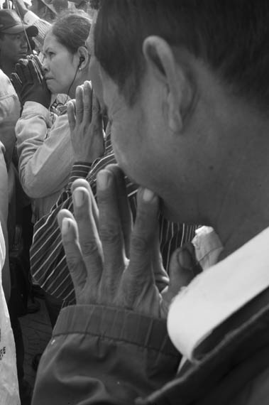 CAMBODIA. Phnom Penh. 22/01/2014: People praying during the 10th commemoration of the assassination of union leader Chea Vichea, when a small crowd, led by Chea Mony, Union Leader and Chea Vichea's brother, Sam Rainsy and Kem Sokha, opposition CNRP Co-Presidents, marched from the FUTWC office to the statue of Chea Vichea.