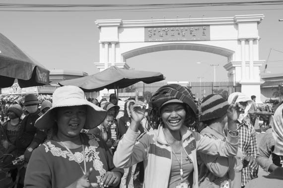 CAMBODIA. Dangkor (Phnom Penh). 28/01/2014: Workers dancing while waiting for their representatives to meet with the managers when about 1000 garment factory workers at the industrial area of Vattanac II walked out after 11 union leaders were fired.