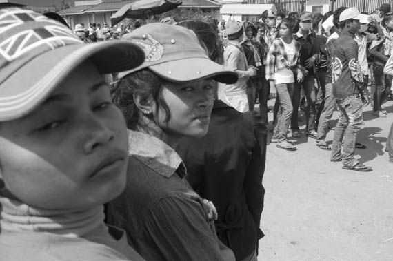 CAMBODIA. Dangkor (Phnom Penh). 28/01/2014: Workers dancing while waiting for their representatives to report on the negotiations with the direction when about 1000 garment factory workers at the industrial area of Vattanac II walked out after 11 union leaders were fired.