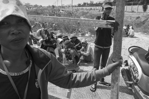 CAMBODIA. Dangkor (Phnom Penh). 28/01/2014: Workers waiting for their representatives to report on the negotiations with the direction when about 1000 garment factory workers at the industrial area of Vattanac II walked out after 11 union leaders were fired.