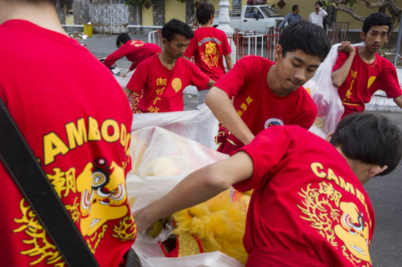 CAMBODIA. Phnom Penh. 30/01/2014: Group celebrating Chinese New Year at the Royal Palace wrapping up the lion's heads.