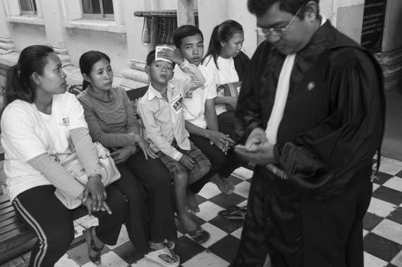 CAMBODIA. Phnom Penh. 11/02/2014: Family of Voan Pov, Union Leader, wait for the trial to start while workers and supporters demonstrate outside the Appeals Court where the judges will decide on a request for bail for 21 workers, activists and union leaders arrested during the violent crackdown of a workers strike on January 2nd and 3rd.