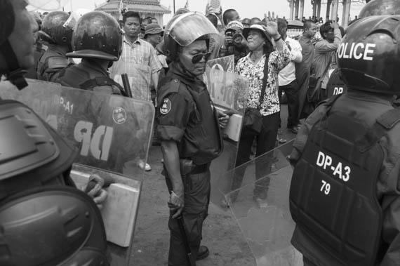 CAMBODIA. Phnom Penh. 11/02/2014: After the Appeals Court issued a no bail verdict to the 21 who were arrested during the violent military crackdown on working strikers on January2nd and 3d, a small group, led by monks from the Independent Monk Network for Social Justice (IMNSJ), gathered at the Preah Ang Dong riverside pagoda before being dispersed by an important riot police force when marching towards the Royal Palace.