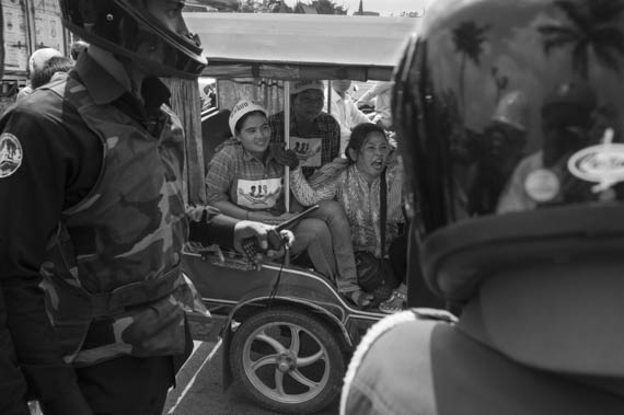 CAMBODIA. Phnom Penh. 11/02/2014: After the Appeals Court issued a no bail verdict to the 21 who were arrested during the violent military crackdown on working strikers on January2nd and 3d, a small group, led by monks from the Independent Monk Network for Social Justice (IMNSJ) and land rights activists, here seen being chased away by communal security forces, gathered at the Preah Ang Dong riverside pagoda before being dispersed by an important riot police force when marching towards the Royal Palace.