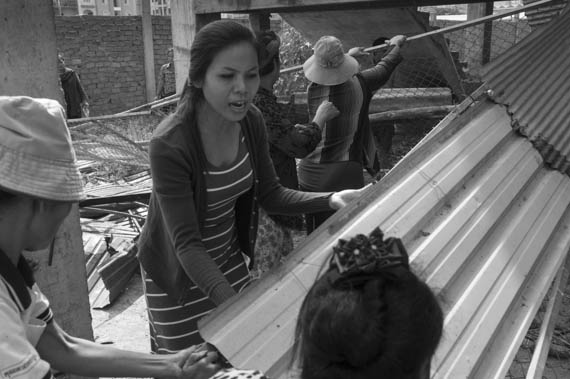 CAMBODIA. Phnom Penh. 12/02/2014: Inhabitants from the Borei Keila community which was evicted in January 2012 and had to live in unhealthy shacks near a building they were promised an appartment in, tear down the fence giving access to the empty building.