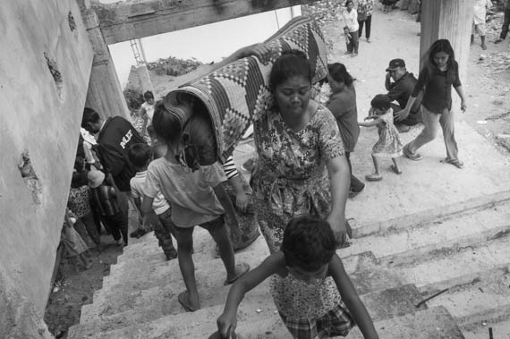 CAMBODIA. Phnom Penh. 12/02/2014: Inhabitants from the Borei Keila community which was evicted in January 2012 and had to live in unhealthy shacks near a building they were promised an appartment in, rush to take possession of a lot in the empty building.