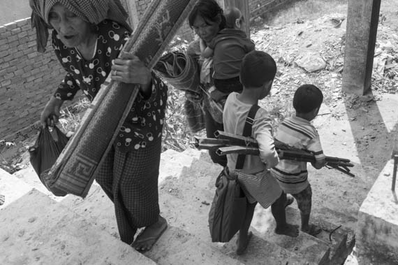 CAMBODIA. Phnom Penh. 12/02/2014: Inhabitants from the Borei Keila community which was evicted in January 2012 and had to live in unhealthy shacks near a building they were promised an appartment in, rush to take possession of a lot in the empty building.