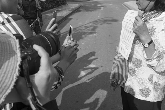 CAMBODIA. Phnom Penh. 6/03/2014: Journalists photograph a document held by a woman from the Boeung Kak lake community who demonstrated and was arrested the day before, requesting a meeting about a retroactive compensation for their eviction with City Hall officials again