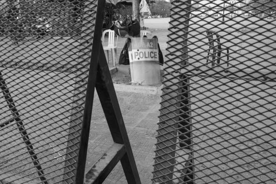 CAMBODIA. Phnom Penh. 8/03/2014: Fences and riot police prevent a public forum organised by labour unions to be held at Freedom Park on International Women's Day.