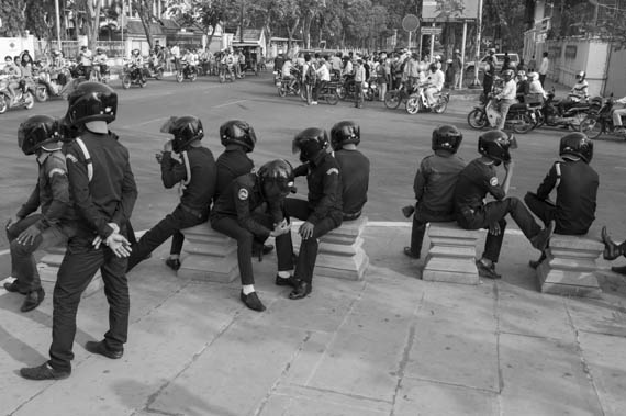 CAMBODIA. Phnom Penh. 8/03/2014: Municipal security guards take a rest after having dispersed onlookers and journalists to prevent a public forum organised by labour unions to be held at Freedom Park on International Women's Day.