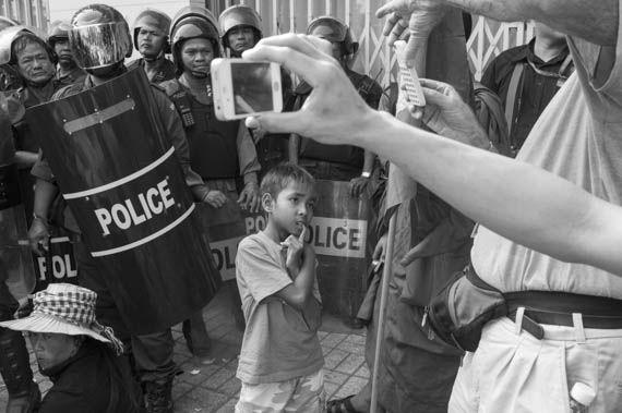 CAMBODIA. Phnom Penh. 8/03/2014: Members from Boeung Kak lake and Borei Keila, joined by monks from the Independent Monk Network for Social Justice (IMNSJ) are prevented by riot police to march to the Ministry of Women's Affairs to deliver a petition on International Women's Day.