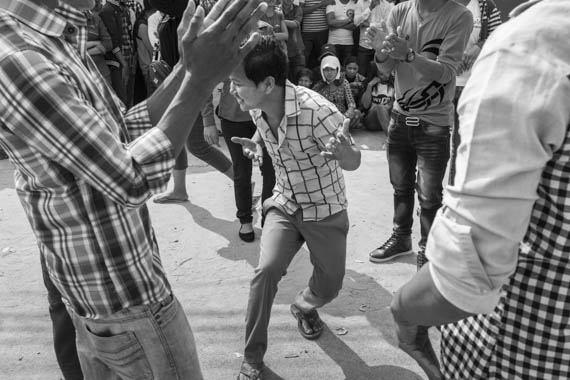 CAMBODIA. Phnom Penh 13/03/2014: Workers at the E.Z. International Garment Factory dance in front of the factory to the sound of house music when on a strike to protest the non observance of labour laws by the management.