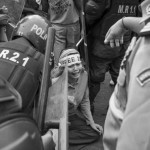 CAMBODIA. Phnom Penh 4/04/2014: Yorm Bopha, land rights activist, being contained by riot police when supporters of Vorn Pov, union leader jailed during the early january crackdown by the army of a worker's strike, demonstrate at the municipal court during a bail request hearing.